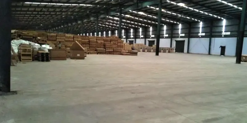 Bulk timber and packaged goods stacked along a warehouse wall