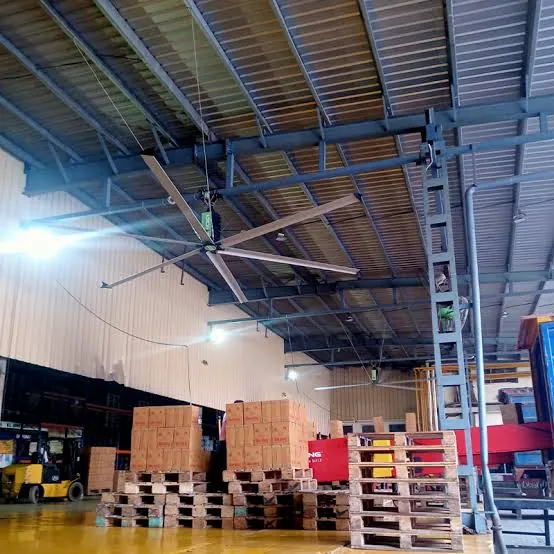 Forklift moving stacked pallets inside a working warehouse